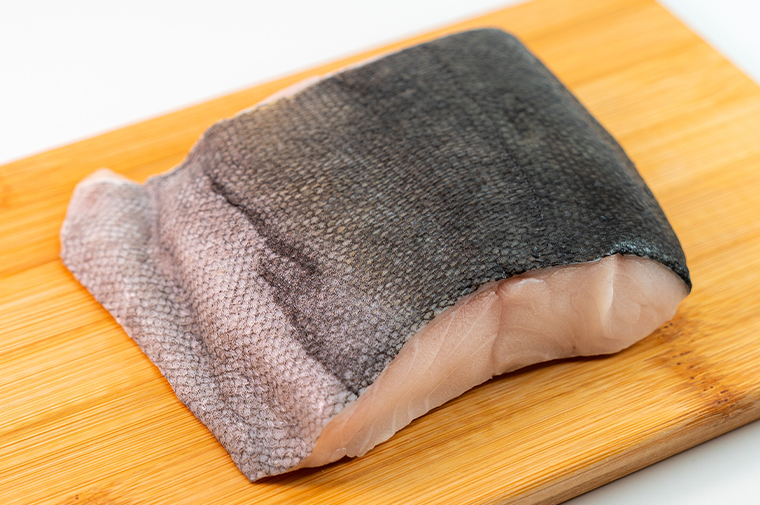 Pacific Dream Seafoods Black Cod on cutting board skin up